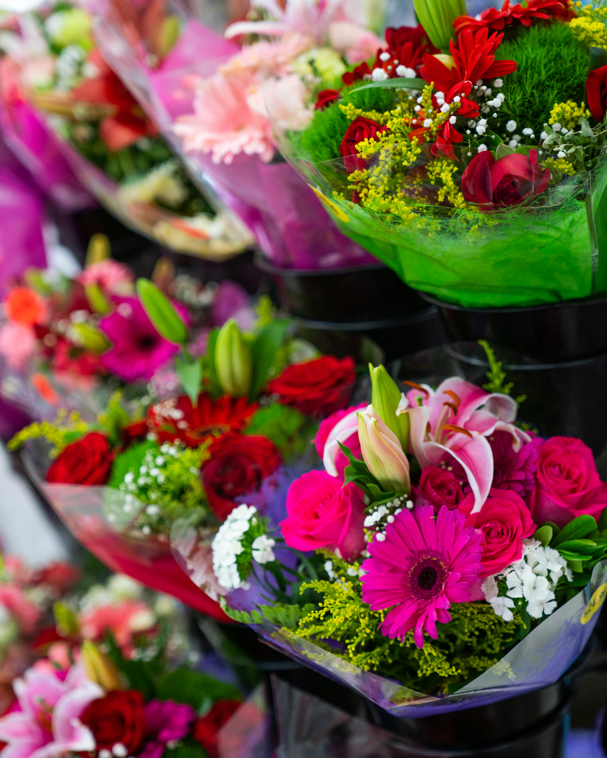 Bright bouquets of roses, lilies, and gerbera daisies in the flower section